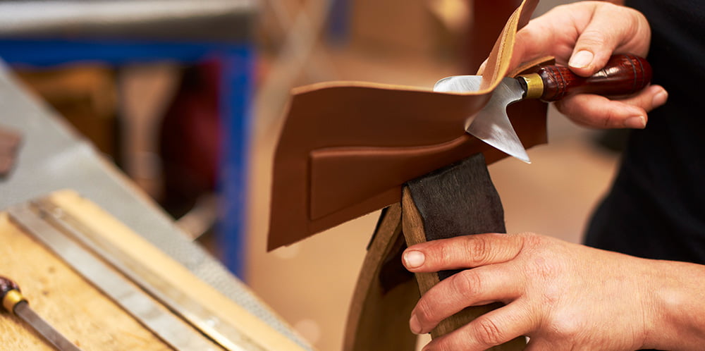 HAND CUTTING EXCESS LEATHER ON WAVE CUP HANDLE