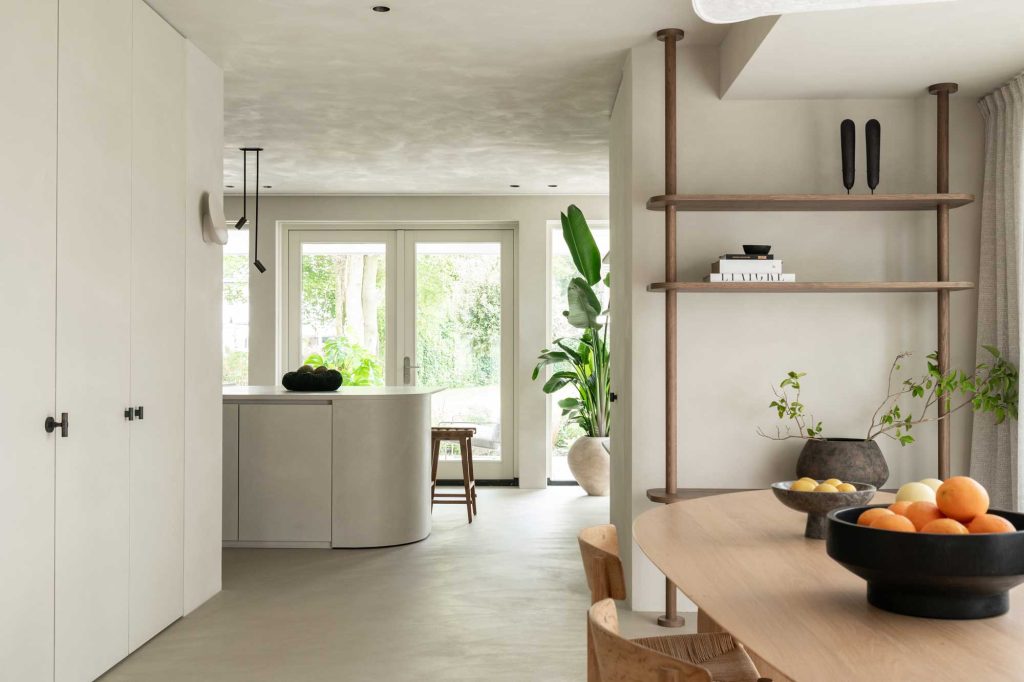 a minimalist interior with clean off white colours amongst micro cement, natural wooden furniture and curver kitchen island.
