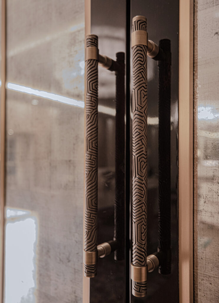 Two door pulls, made by Turnstyle Designs, adorn luxury glass double doors in a high end London apartment. The door pulls are the Labyrinth designs, an intricate resin pattern that is inspired by coral and the sea.