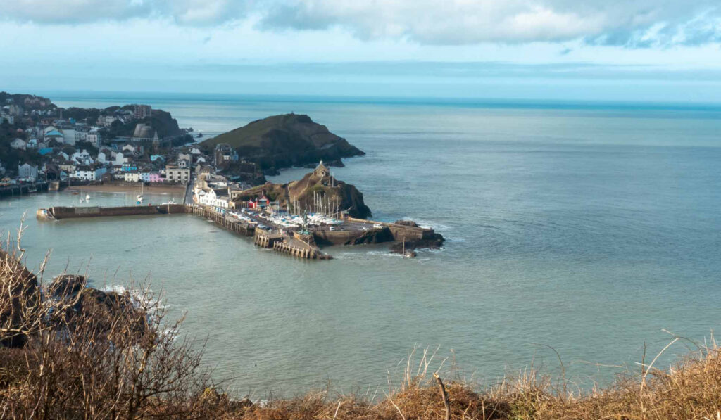 A beautiful view of Ilfracombe harbour from Hillsborough common. The sea is a turquoise blue to match the sky on a sunny spring day.