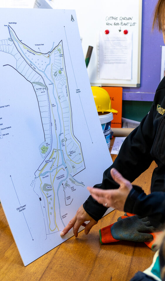 A map of Ashcombe Gardens is shown to a group of volunteers.