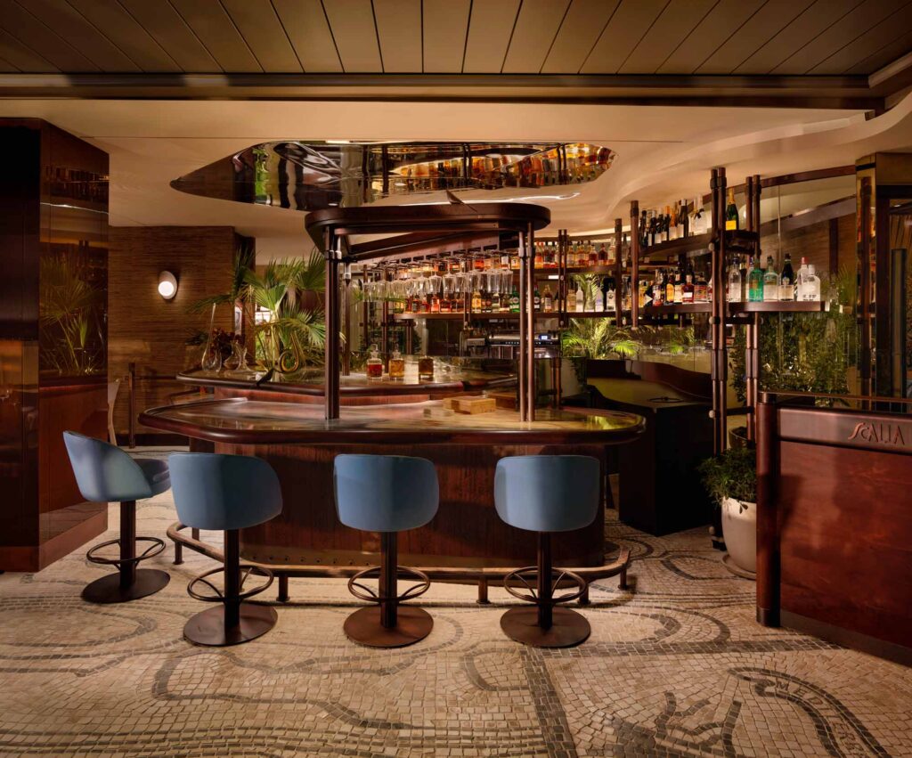 4 bar stools in rich dark blue fabric sit aside a luxury curved bar area within the fine dining restaurant. This project is called Scalla and is based in Istanbul, Turkey.