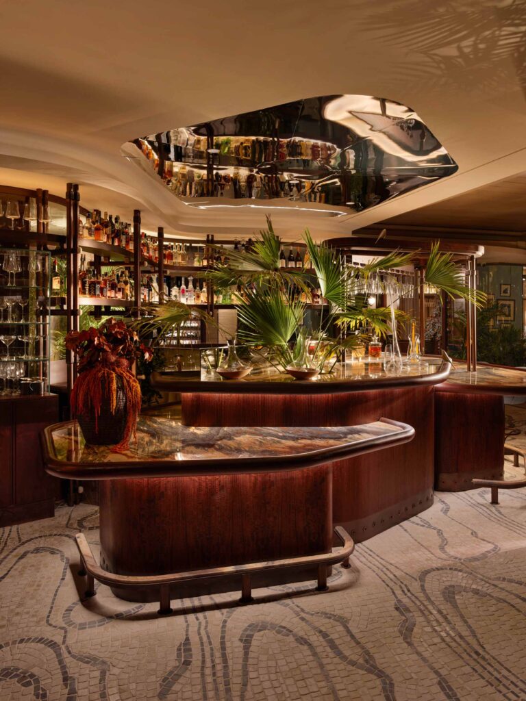 The bar area of a luxury fine dining restaurant. The dark wood and natural textures are inspired by the outside world.